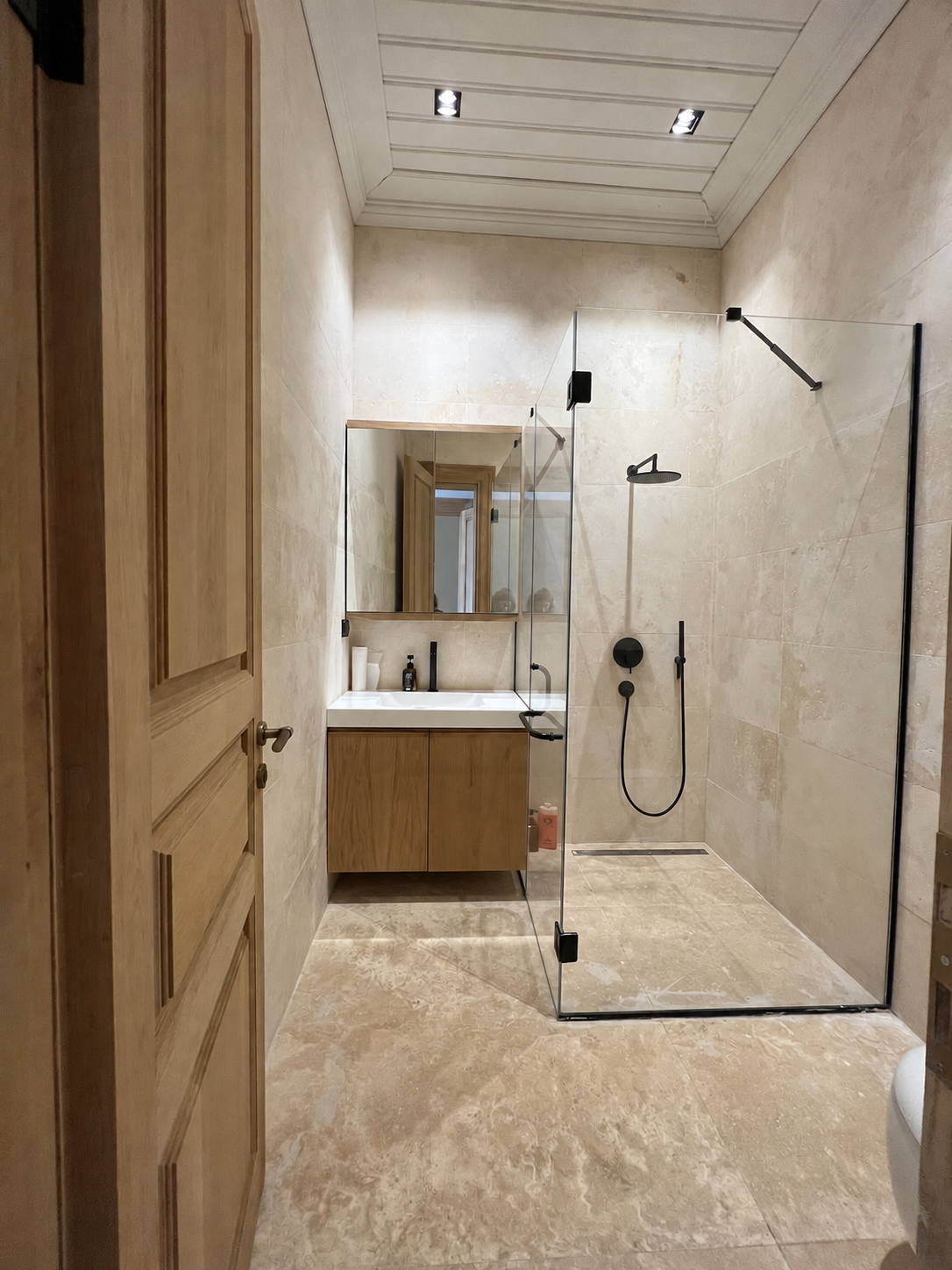 Doğal taş yüzeyli, ahşap mobilyalı banyo